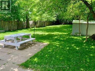 Toronto (Islington-City Centre West) apartment for rent - A white picnic table is in the middle of a green yard.