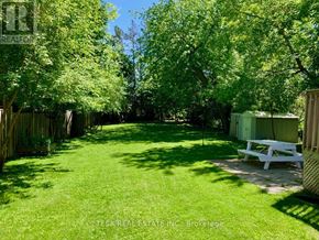 Toronto (Islington-City Centre West) apartment for rent - A backyard with a white bench and a wooden fence.