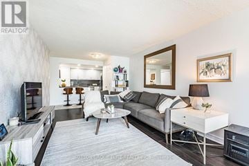 Mississauga (Cooksville) condo for rent - A modern living room with a grey sofa and a coffee table.