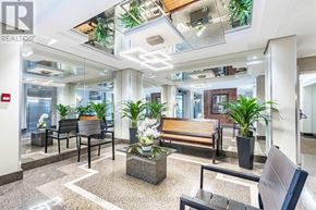 Mississauga (Cooksville) condo for rent - A modern office lobby with a glass ceiling and a variety of plants.
