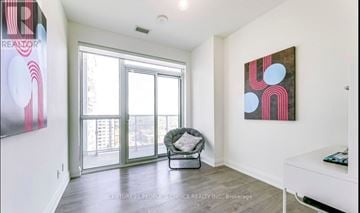 Oakville (Co Central) condo for rent - A realtor painting is on the wall in a spacious living room.