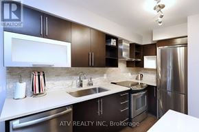 Toronto (Islington-City Centre West) condo for rent - A modern kitchen with dark brown cabinets and stainless steel appliances.