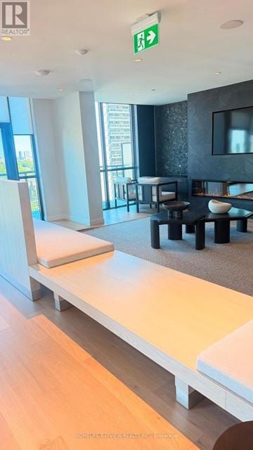 Toronto (Mount Pleasant West) condo for rent - A modern living room with a long white couch and a television.