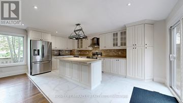 Oshawa (Kedron) apartment for rent - A spacious kitchen with white cabinets and a central island.