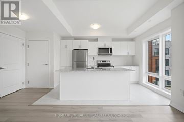 Toronto (Malvern) townhouse for rent - A modern kitchen with white cabinets and appliances.