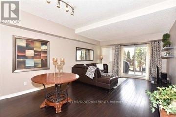 Vaughan (West Woodbridge) condo for rent - A living room with a round wooden table and a couch with a white and black patterned throw.