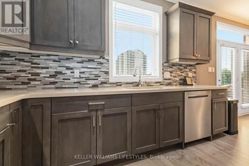London South (South W) apartment for rent - A kitchen with dark wood cabinets and a stone backsplash.