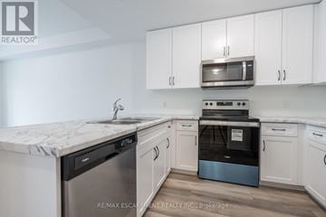 Hamilton (Winona Park) townhouse for rent - A kitchen with white cabinets and a marble countertop.
