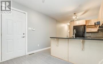 Ottawa townhouse for rent - A kitchen area with a white door and a counter with a microwave and oven.