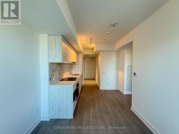Toronto (Bay Street Corridor) condo for rent - A spacious kitchen with white cabinets and a marble island.