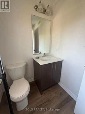 Cambridge townhouse for rent - A bathroom with a toilet, sink and mirror.