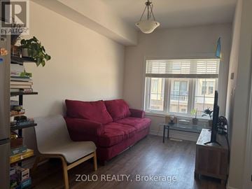 Cambridge townhouse for rent - A living room with a red couch and a television.