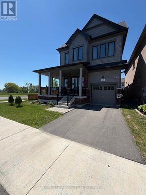 Oshawa (Eastdale) apartment for rent - A house with a grey garage door and a driveway in front.