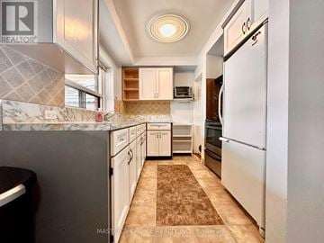 Toronto (Beechborough-Greenbrook) apartment for rent - A kitchen with a white refrigerator and brown floor tiles.