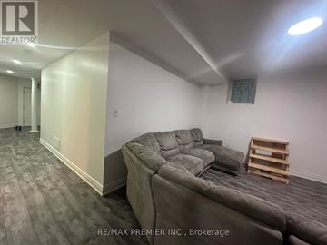 Mississauga (Churchill Meadows) apartment for rent - A living room with a grey couch and a wooden stool.