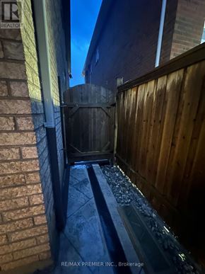 Mississauga (Churchill Meadows) apartment for rent - A wooden fence and a brick wall with a metal gate.