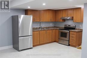 Brampton (Fletcher's Meadow) apartment for rent - A kitchen with wooden cabinets and a stainless steel refrigerator.