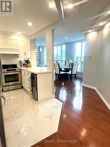 Toronto (Mimico) condo for rent - A modern kitchen with white cabinets and a wooden floor.