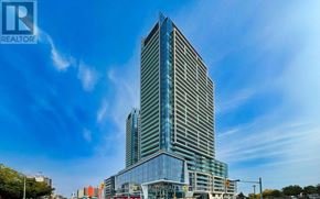 Toronto (Newtonbrook East) condo for rent - A tall building with a glass facade stands under a blue sky.