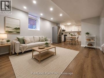 Richmond Hill (Rouge Woods) apartment for rent - A well-lit, modern living room with a white sofa, wooden coffee table, and a painting on the wall.