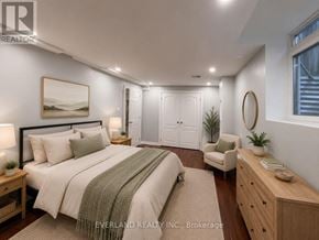 Richmond Hill (Rouge Woods) apartment for rent - A bedroom with a large bed, a chair, and a painting on the wall.