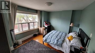 Toronto (Palmerston-Little Italy) townhouse for rent - A bedroom with a bed, a window, and a teddy bear on the bed.