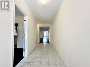 Bradford West Gwillimbury (Bond Head) apartment for rent - A long hallway with a door on the left and a window on the right.