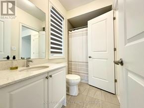Bradford West Gwillimbury (Bond Head) apartment for rent - A white bathroom with a sink, toilet and a mirror.