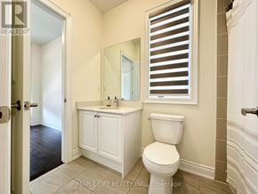 Bradford West Gwillimbury (Bond Head) apartment for rent - A white bathroom with a toilet, sink, and mirror.
