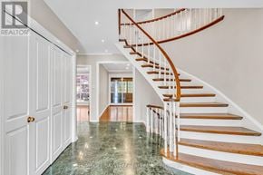 Toronto (Bridle Path-Sunnybrook-York Mills) apartment for rent - A spacious hallway with a curved staircase and a marble floor.