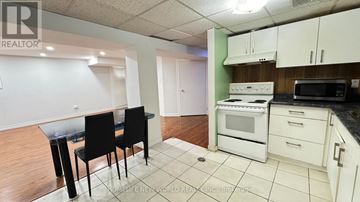 Richmond Hill (Crosby) apartment for rent - A kitchen with white cabinets and a black table.