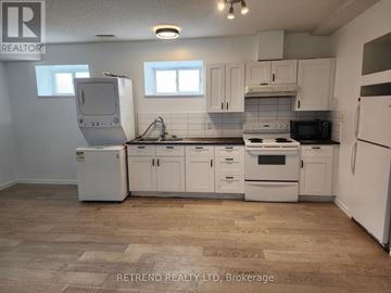 Cobourg apartment for rent - A kitchen with white appliances and cabinets.