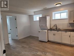 Cobourg apartment for rent - A kitchen with a white fridge and wooden floors.