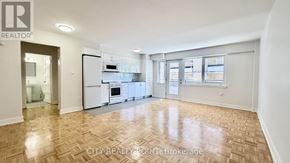 Toronto (Yonge-St. Clair) condo for rent - A spacious kitchen with white appliances and a wooden floor.