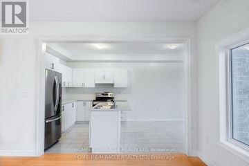 New Tecumseth apartment for rent - A kitchen with white cabinets and appliances is shown.