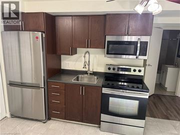 Kitchener apartment for rent - A kitchen with brown cabinets and stainless steel appliances.