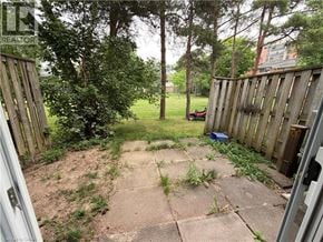 Waterloo townhouse for rent - A backyard with a wooden fence and a concrete patio.