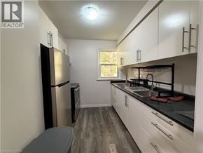 Waterloo townhouse for rent - A kitchen with white cabinets and a black countertop.
