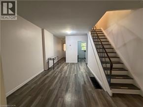 Waterloo townhouse for rent - A hallway with a staircase and a door at the end.
