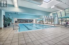Toronto (Steeles) condo for rent - A large indoor swimming pool with a tiled floor and a glass wall.