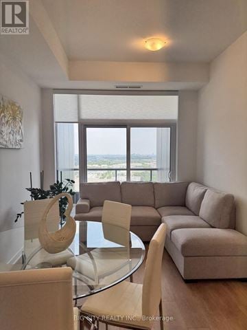 Vaughan (Concord) condo for rent - A living room with a glass table and a couch.