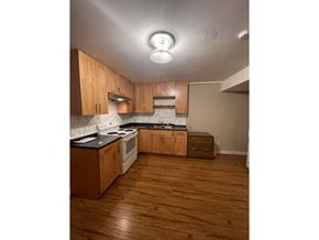 Delta apartment for rent - A kitchen with wooden cabinets and a white stove top oven.