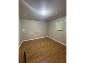 Delta apartment for rent - A room with wooden flooring and a window with blinds.