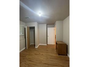Delta apartment for rent - A room with wooden floors and a light on the ceiling.