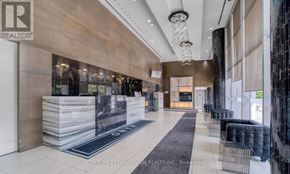 Mississauga (City Centre) condo for rent - A modern office lobby with a reception desk and a glass wall.