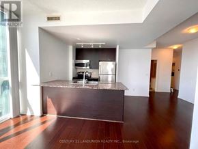 Mississauga (City Centre) condo for rent - A modern kitchen with dark wood floors and a granite countertop.