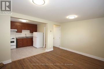 Oshawa (Mclaughlin) multi-family for rent - A kitchen with wooden cabinets and a white refrigerator.
