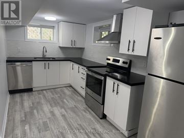 Milton (Om Old Milton) apartment for rent - A kitchen with white cabinets and a stainless steel refrigerator.