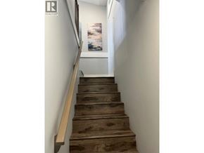 Vancouver apartment for rent - A staircase with wooden steps and a beige handrail.