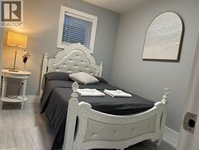 Vancouver apartment for rent - A bedroom with a white bed and a grey wall.